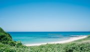 山口県長門市の大浜海岸。青く澄んだ海と白い砂浜が広がり、緑豊かな丘に囲まれた美しい夏のビーチの風景。