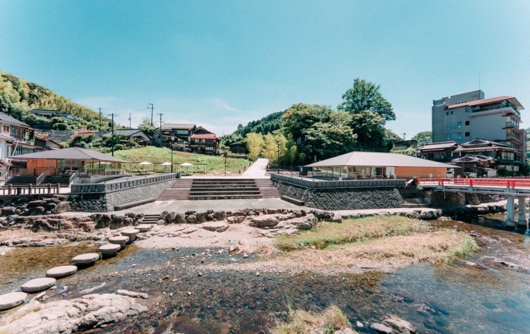 山口県の長門湯本温泉。音信川の飛び石と、丘に続く温泉街の美しい景色が広がります。